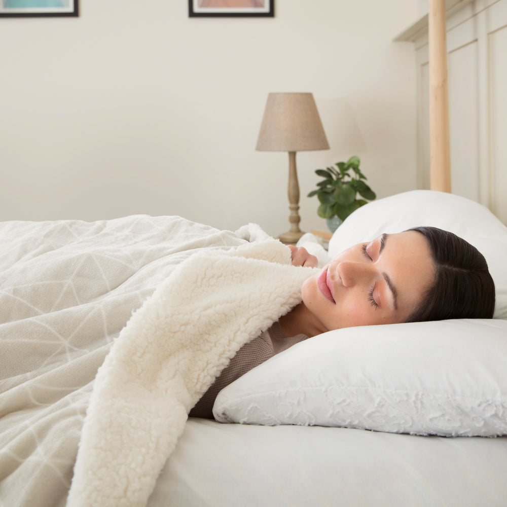 Woman sleeping in the Dreamland Nap Time Warming Sherpa Blanket