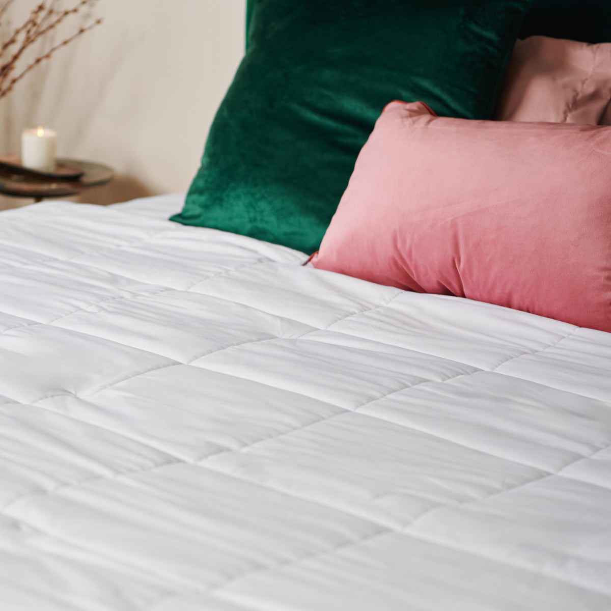 A heated king duvet with a few cushion on the bed.